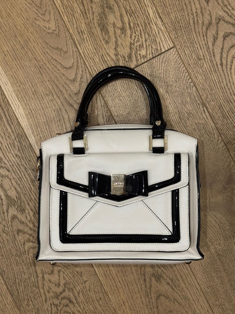 White Handbag With Black Trim And Bow Detail