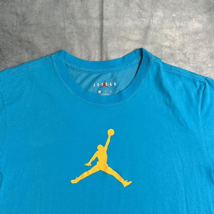 Nike blue Jordan T-shirt with a  yellow Jumpman logo detailing in the centre of the T-shirt, also in image 2