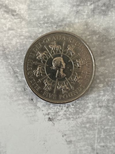 The coin presented is a British 5 pound coin from 1993, minted to commemorate the 40th anniversary of the coronation of Queen Elizabeth II.