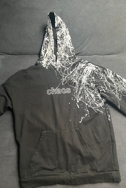 Black Hoodie With White Splatter Design And 'Chaos' Text