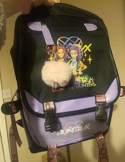 Black And Purple Backpack With Cartoon Graphic And Pompom Keychain