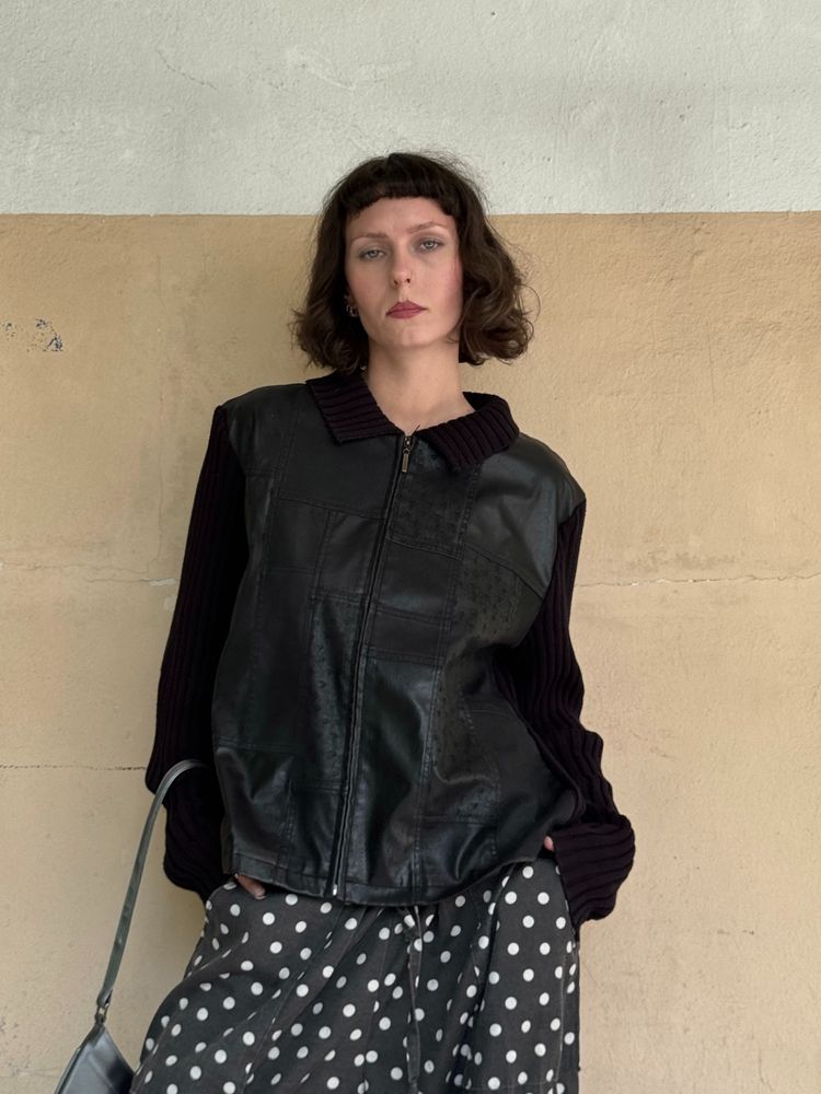 black zip-up leather vest with black ribbed sleeves and collar
