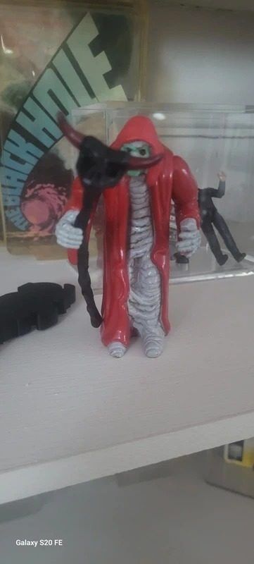 Red Hooded Figure Toy With Green Face And Staff image 1