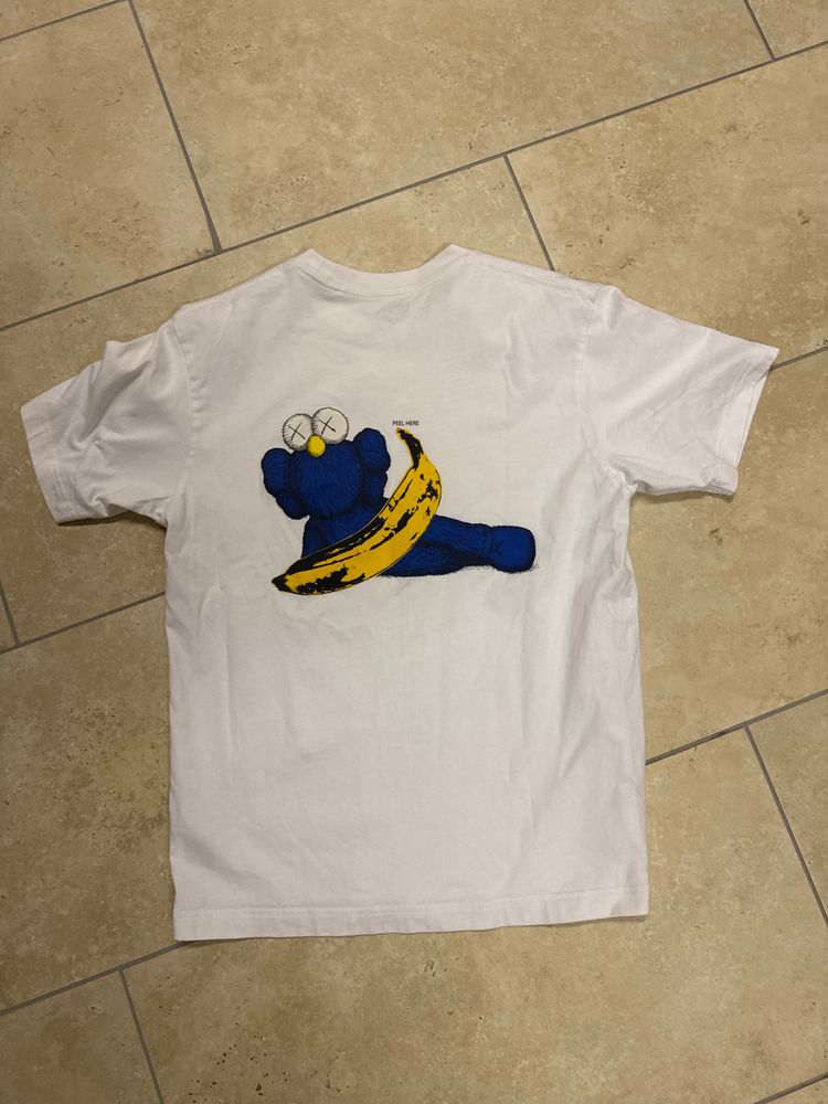 White Graphic T-Shirt With Blue Character And Banana Design obraz 1