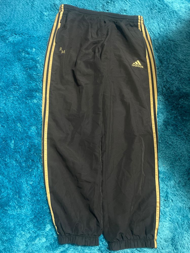 Adidas black track pants with gold stripes